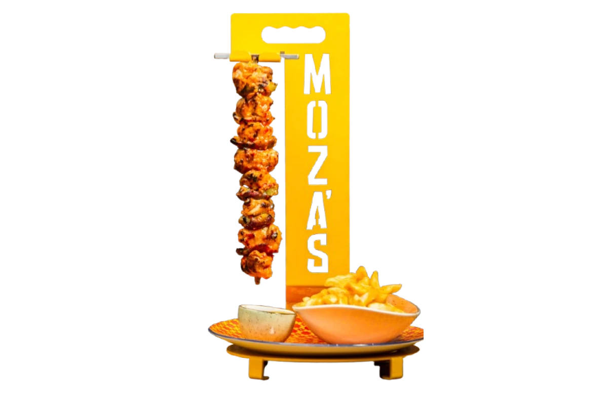 moza's chicken espetada with chips suspended on yellow skewer stand